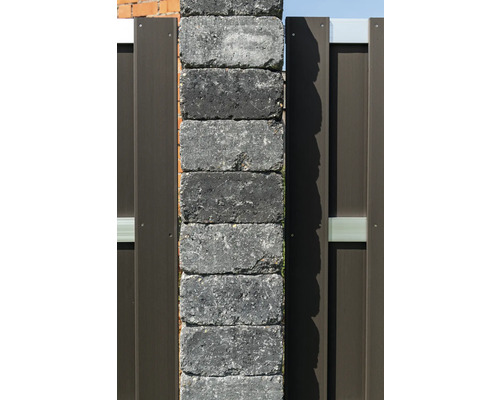 Betonnen hekpaal van gestapelde stenen met metalen elementen