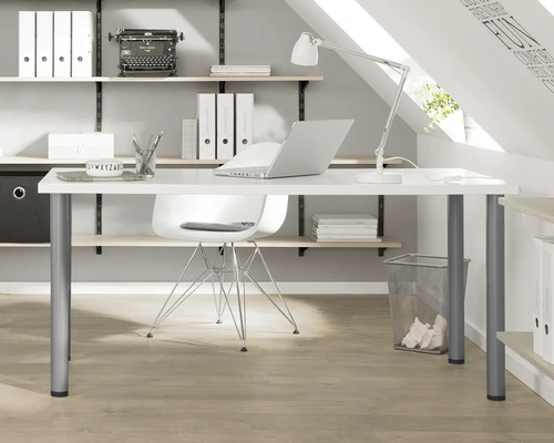 Werkkamer met bureau, stoel, rekken en kantoorbenodigdheden op een zolder.