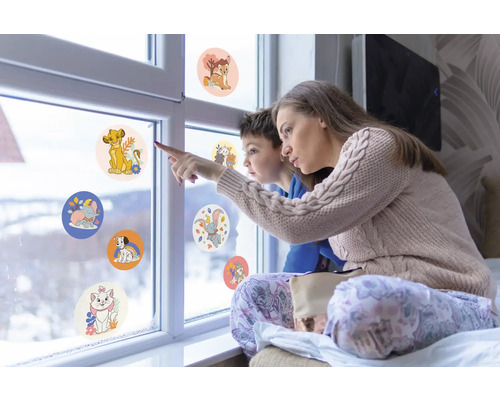 Moeder en kind kijken naar raamstickers met dierenmotieven op een raam