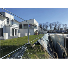 Bouwplaats met bouwschutting en nieuwe gebouwen
