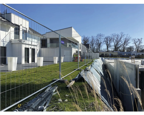 Bouwplaats met bouwschutting en nieuwe gebouwen