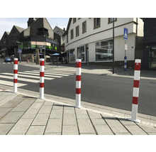 Rood-witte veiligheidspollers bij een zebrapad voor verkeersregeling.
