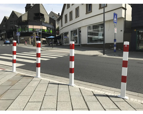 Rood-witte veiligheidspollers bij een zebrapad voor verkeersregeling.
