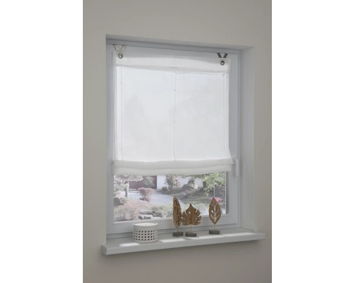 Raam met witte vouwzonwering en decoratie op de vensterbank