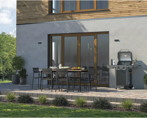 Terras met barbecue, eettafel en stoelen voor het huis
