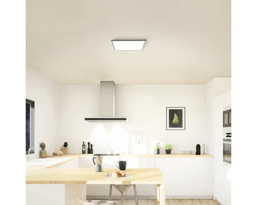 Lichte keuken met plafondlamp, afzuigkap en keukenmeubels