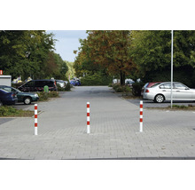 Drie rood-wit gestreepte afzetpalen op een parkeerplaats
