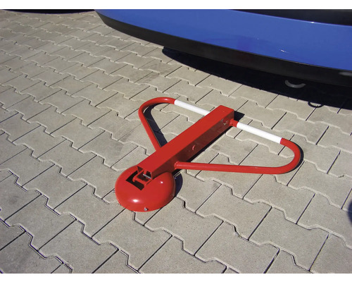 Rode parkeerbeugel op straatstenen voor een auto