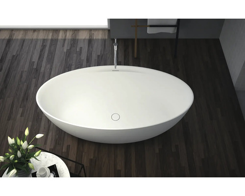 Vrijstaand bad in een badkamer met houten vloer.