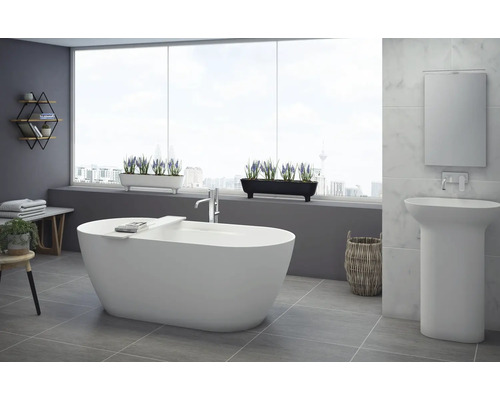 Moderne badkamer met vrijstaand bad, wastafel en decoratieve elementen voor een lichte en vriendelijke sfeer.