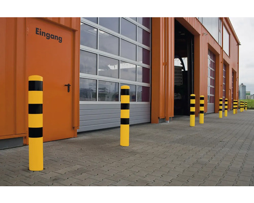 Een rij aanrijdbeveiligingspalen voor een gebouw met poorten.