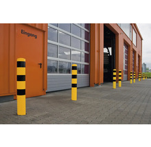 Gele stootpalen met zwarte strepen voor een gebouw