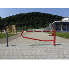 Een rood-wit gestreepte slagboom op een verhard pad in een buitenomgeving.