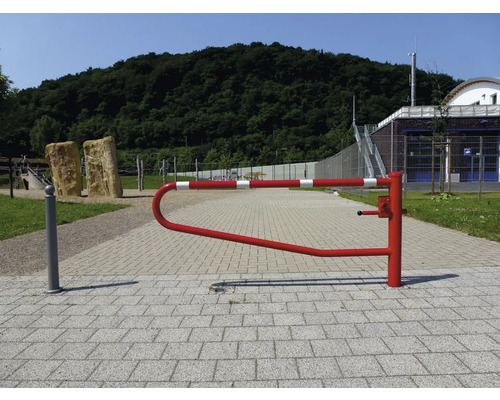 Een rood-wit gestreepte slagboom op een verhard pad in een buitenomgeving.