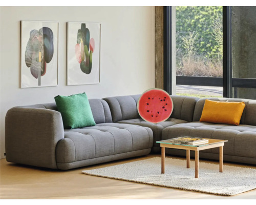 Woonkamer met grijze hoekbank, kussens, salontafel en wanddecoraties