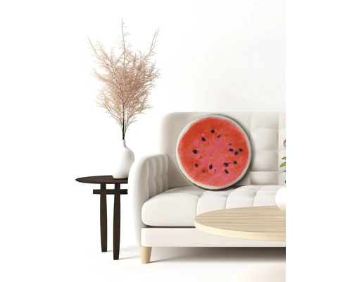 Decoratief watermeloenkussen op een bank in een lichte kamer.