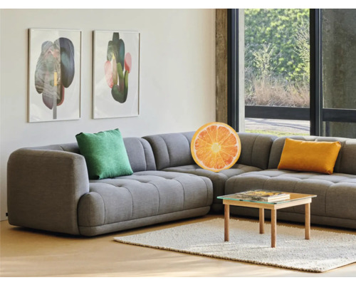 Woonkamer met grijze hoekbank, kussens en salontafel