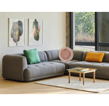 Woonkamer met grijze hoekbank, sierkussens, salontafel en kunst aan de muur