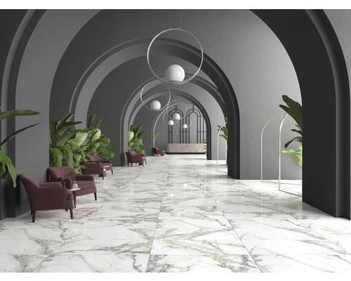 Lobby met marmeren vloer, fauteuils en beplanting onder gewelfde doorgangen.