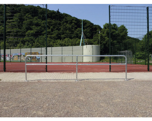 Buitenaanzicht van een sportveld met metalen hek en ballenvanger.