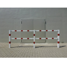 Wit en rood hekwerk voor een grijze muur
