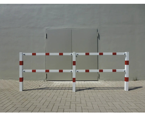 Wit en rood hekwerk voor een grijze muur