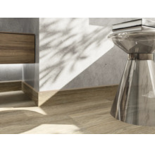 Detailopname van een interieur met houten vloer, plint en een bijzettafel