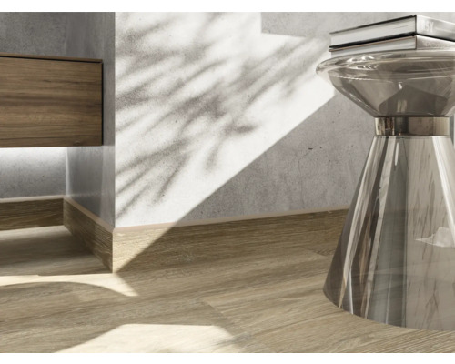 Detailopname van een interieur met houten vloer, plint en een bijzettafel