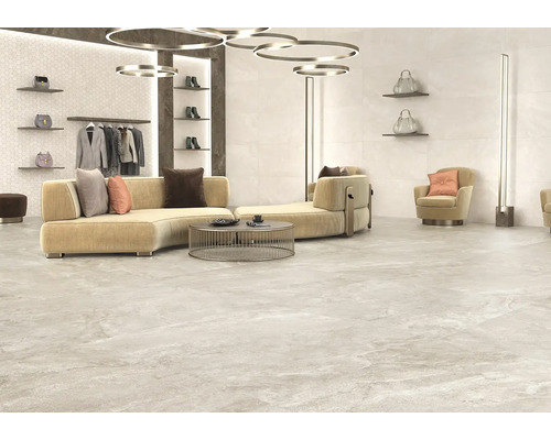 Lichte ruimte met bank, fauteuil en vloertegels in steenlook