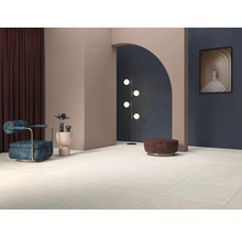 Lichte betegelde ruimte met fauteuil, staande lamp en decoratie