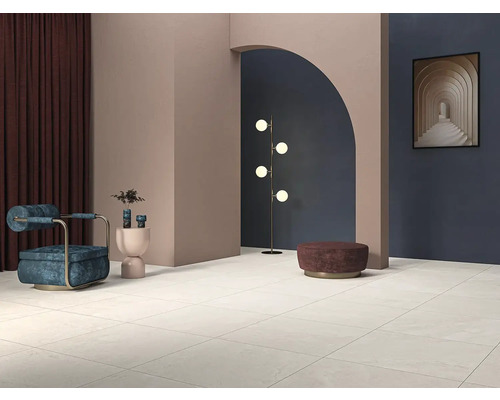 Lichte betegelde ruimte met fauteuil, staande lamp en decoratie