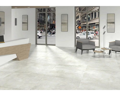 Lichte ruimte met vloertegels, receptie en zithoek met uitzicht op de straat