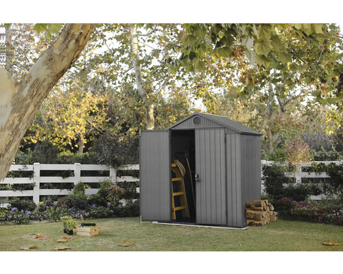 Tuinscene met tuinhuis, ladder en brandhout in de tuin