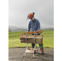 Een man met veiligheidshelm en vizier werkt met een houtklover waarop houtblokken liggen.