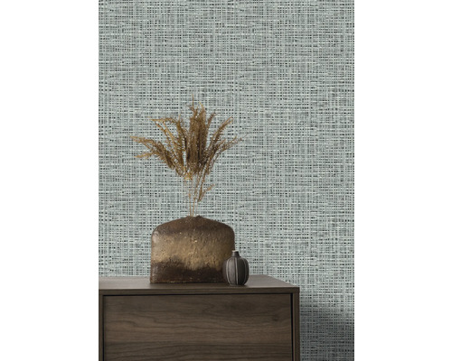 Close-up van een muur met textielbehang, een dressoir en vazen.