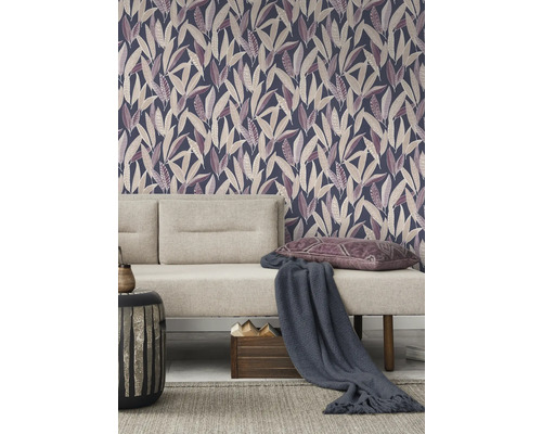 Woonkamer met patroonbehang, bank, kussens en bijzettafel