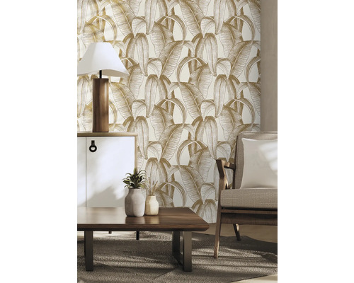 Woonkamer met behang met bladerpatroon, dressoir, tafellamp, salontafel en fauteuil