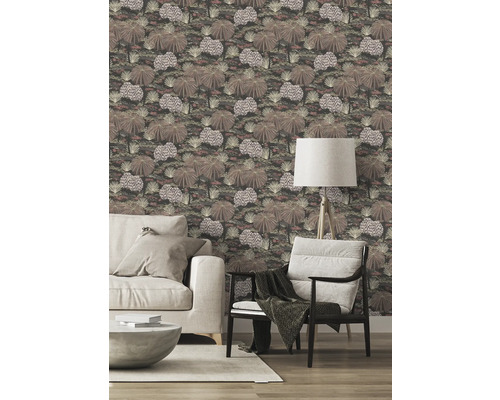 Woonkamer met patroonbehang, bank, fauteuil en staande lamp.