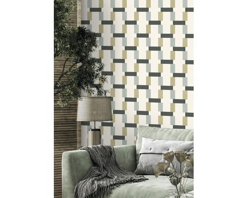 Woonkamer met behangpatroon, bank en lamp.