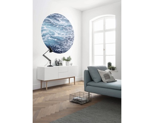 Woonkamer met dressoir, lamp, bank, ronde muurschildering en raam