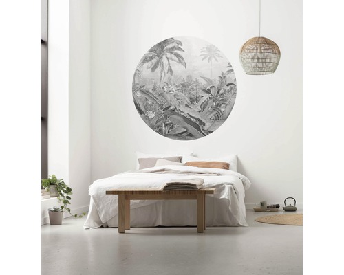 Slaapkamer met rond junglebehang boven het bed, houten tafel en rotan hanglamp