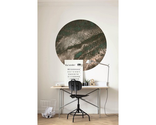 Werkkamer met bureau, stoel, kalender en een ronde muurdecoratie