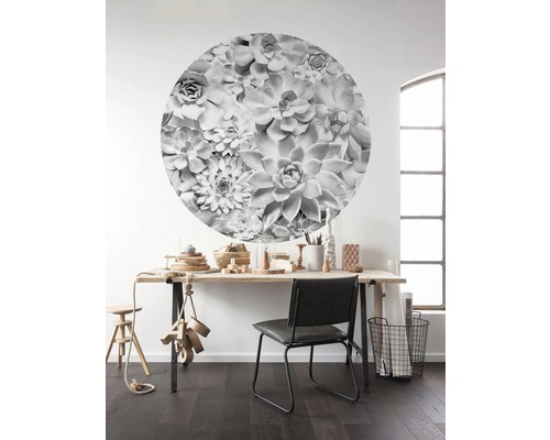 Wanddecoratie met een rond succulentenmotief boven een bureau.