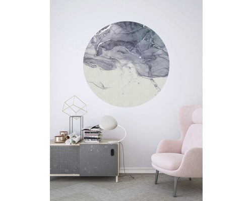 Woonkamer met ronde wanddecoratie met abstract patroon boven een kast en naast een fauteuil