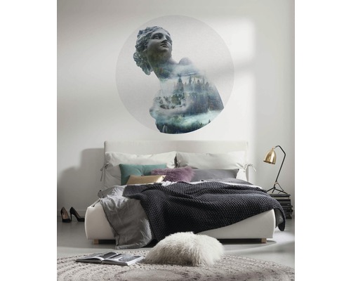 Slaapkamer met bed, lamp, vloerkleed en wanddecoratie met antiek standbeeld en bosmotief