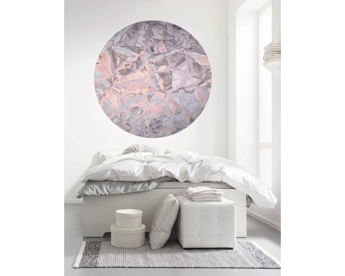 Slaapkamer met bed, kruk, tapijt en ronde wanddecoratie in kristaldesign voor een lichte sfeer.