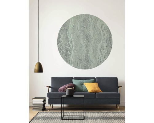 Woonkamer met bank, salontafel, theepot, kussens, lamp, stapel boeken, vloerkleed en muurdecoratie