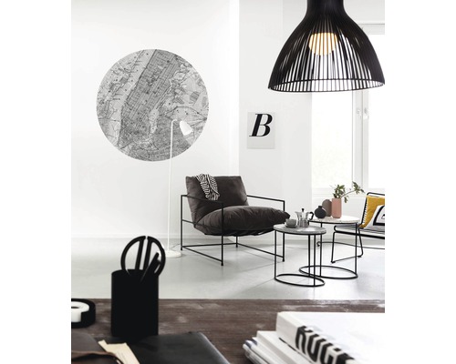 Lichte woonkamer met fauteuil, bijzettafels, hanglamp en muurdecoratie