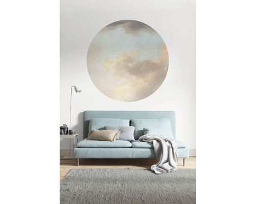 Woonkamer met bank, tapijt en wanddecoratie met wolkenmotief