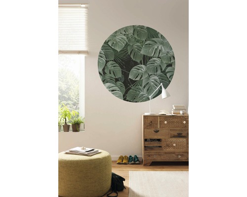 Woonkamer met raam, dressoir, kruk en cirkelvormige muurschildering met plantmotieven